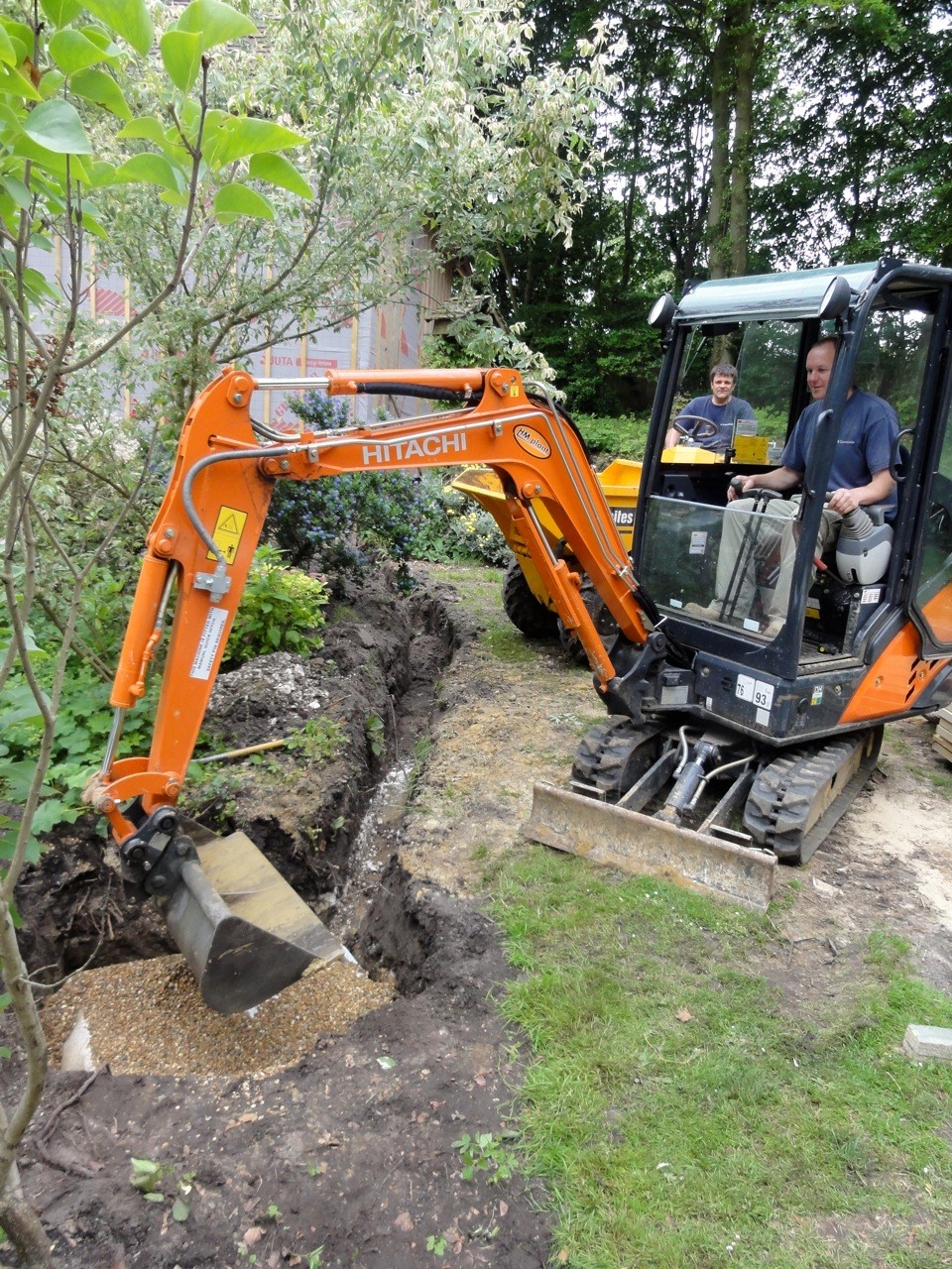 Mini digger with operator on a PB Groundworks site in Surrey
