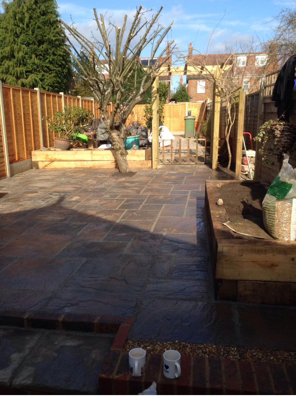 Finished sandstone patio with timber pergola, raised bed and feature tree